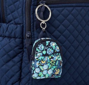 A backpack-shaped keychain with a floral design printed on it.