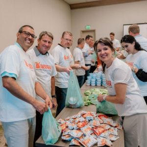 Volunteers pack food for kids